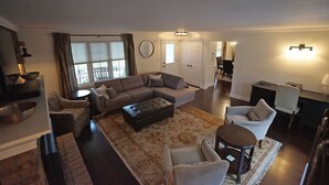 A spacious living room with a large sectional sofa, a round coffee table, and a dining area with a table and chairs. - Arrowstone Luxury Farmhouse in Historic Old Town, Niagara-on-the-Lake.  (Niagara-on-the-Lake)