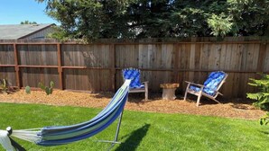 A hammock, two lounge chairs, a wooden fence, and a cactus in a backyard. - Sonoma Valley Vacation Home (Santa Rosa)