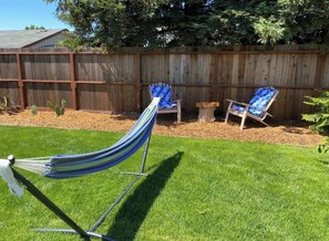A hammock, two lounge chairs, a wooden fence, and a cactus in a backyard. - Sonoma Valley Vacation Home (Santa Rosa)