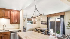 A modern kitchen with wooden cabinets, a central island, and pendant lighting. - Sonoma Valley Vacation Home (Santa Rosa)