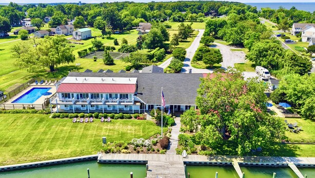 A large building with a swimming pool, dock, and green surroundings. - The Tilghman Island Inn (Tilghman)