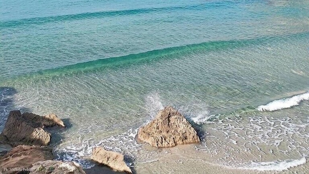 A clear coastal view with calm waters, rocky formations, and a distant sailboat. - Casa Vacanze Iglesias in Centro (Iglesias)