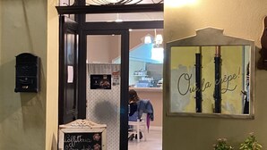 A café entrance with a chalkboard menu, a mirror with a sign, and a staircase leading inside. - Casa Vacanze Iglesias in Centro (Iglesias)