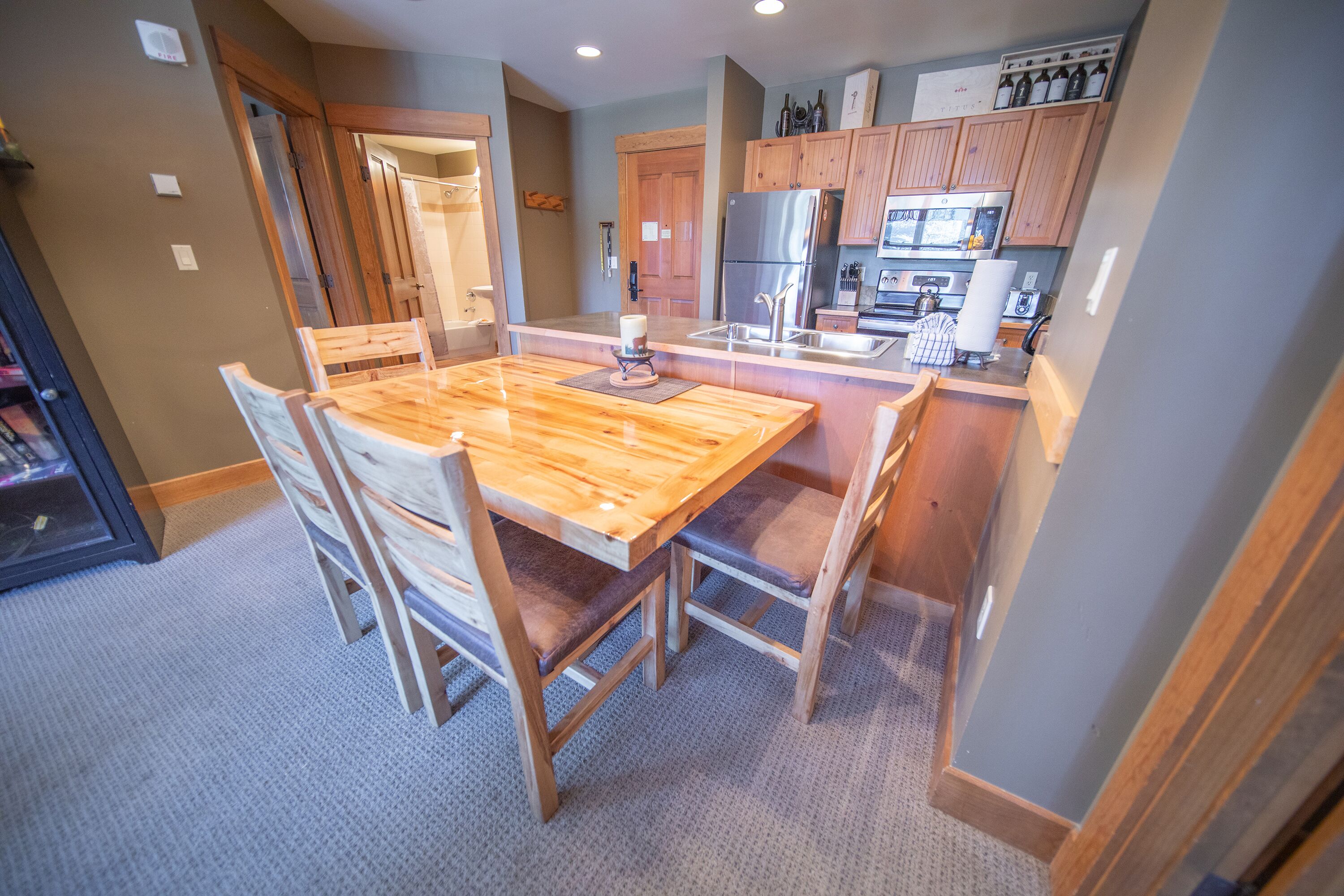 A modern kitchen with wooden cabinets, stainless steel appliances, and a central island with seating.