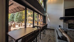 Un interior moderno con comedor, ventanas amplias y chimenea de piedra.