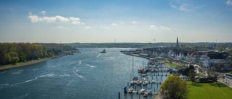 Une rivière avec des bateaux, un quai et des bâtiments le long de la rive.
