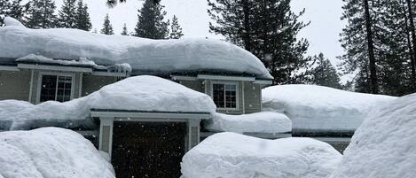 A house covered in snow with a garage entrance.