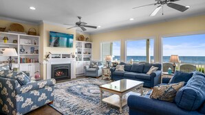 A living room with a fireplace, sofas, a coffee table, and a view of the ocean. - "Sundance" - Oceanfront Home w/ Private Pool, 5 Bedrooms / 4.5 Bathrooms (Holden Beach)