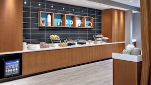 Un bar à petit-déjeuner moderne proposant une variété d’aliments et un réfrigérateur pour les boissons.