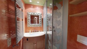 A bathroom with a vanity, a mirror, a shower, and a glass-enclosed shower area. - Apartment house in a fantastic location with lake view. (St. Moritz)
