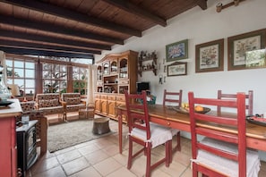 Ein gemütliches Wohnzimmer mit einem Holztisch, Stühlen, einer Couch und einem Kamin.