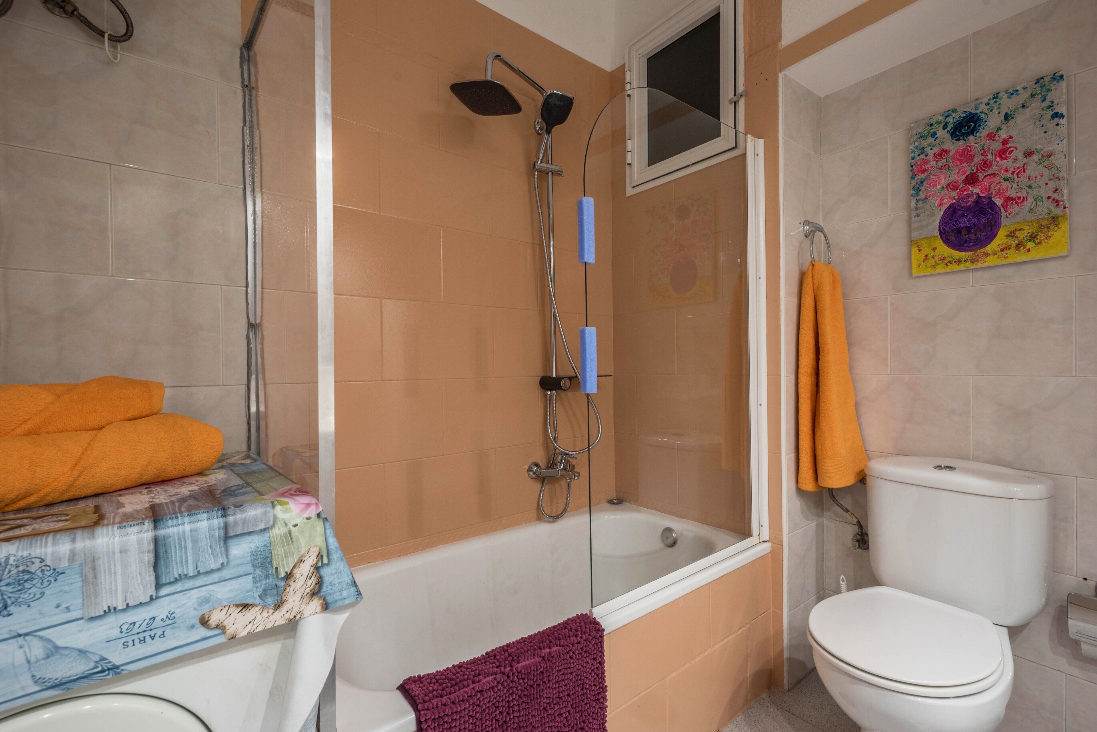 A bathroom with a bathtub, toilet, and shower.