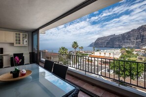 Un balcon avec vue sur la mer et sur la montagne.