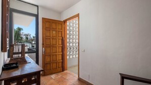 Una puerta de madera con un panel de vidrio, un banco de madera y un piso de baldosas.