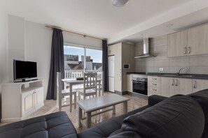 A modern living room with a TV, sofa, and dining area.