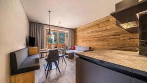 Una cocina moderna con pared de madera, un banco empotrado y un comedor con mesa y sillas.