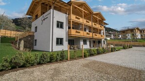 Ein modernes, mehrstöckiges Hotel mit hölzernen Balkonen und einem Steinfundament.