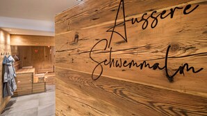A wooden wall with the text 'Aussere Schwermalm' and a clothing rack with jackets. - Apartment “Seebrunn - "Äußere Schwemmalm” with Mountain View, Wi-Fi and Sauna (Ulten)
