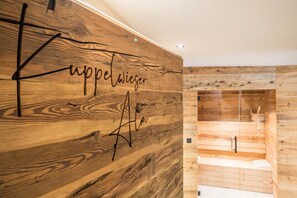 A wooden wall with the text 'Kuppelwiese' and a signature.