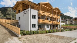 A modern building with a wooden facade, balconies, and a sign indicating it is a guesthouse. - Apartment “Seebrunn - Kühberg Alm” with Mountain View and Lake View (Ulten)