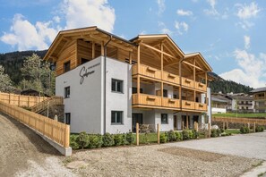 A modern building with a wooden facade, balconies, and a sign indicating it is a guesthouse. - Apartment “Seebrunn - Kühberg Alm” with Mountain View and Lake View (Ulten)