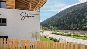 A building with a wooden facade and a sign reading 'Selsgrunn.' - Apartment “Seebrunn - Kühberg Alm” with Mountain View and Lake View (Ulten)