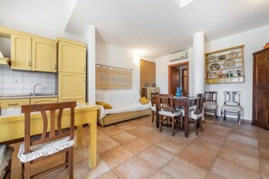 A compact living space with a kitchen, dining area, and a sofa.
