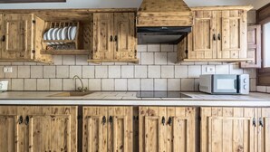 Eine Küche mit Holzausstattung, einer Mikrowelle und einem Spülbecken.