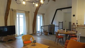 Un salon chaleureux avec une cheminée, une table à manger et un téléviseur.
