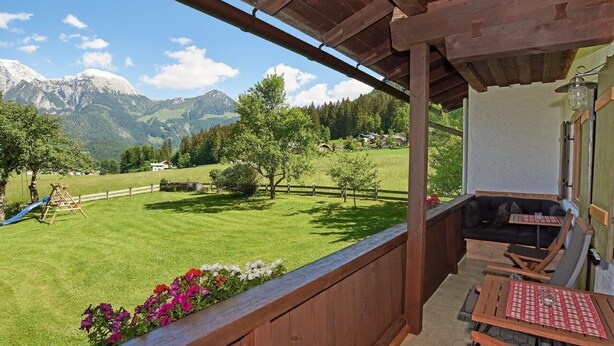 A balcony with wooden railings overlooking a green lawn and mountains. - Ferienwohnung Jenner, 2-4 Personen, Infrarotkabine, 65 qm, Balkon mit Bergblick (Schönau am Königssee)