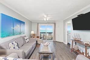 Relax in this ocean-view living area with a sofa, coffee table, and television.