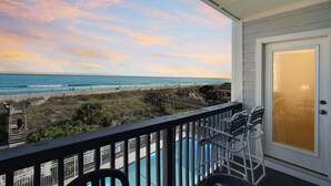 A balcony with a view of the beach and ocean, a pool, and outdoor seating. - Condo w/ Private Balcony & Stunning Beach Views (Surfside Beach)
