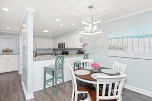 Enjoy meals in the kitchen and dining area with a round table and pendant light.