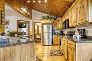 A kitchen with wooden cabinets, stainless steel appliances, and a granite countertop. - Cabin w/Mountain Views-Pool Table-Private Hot Tub (Gatlinburg)