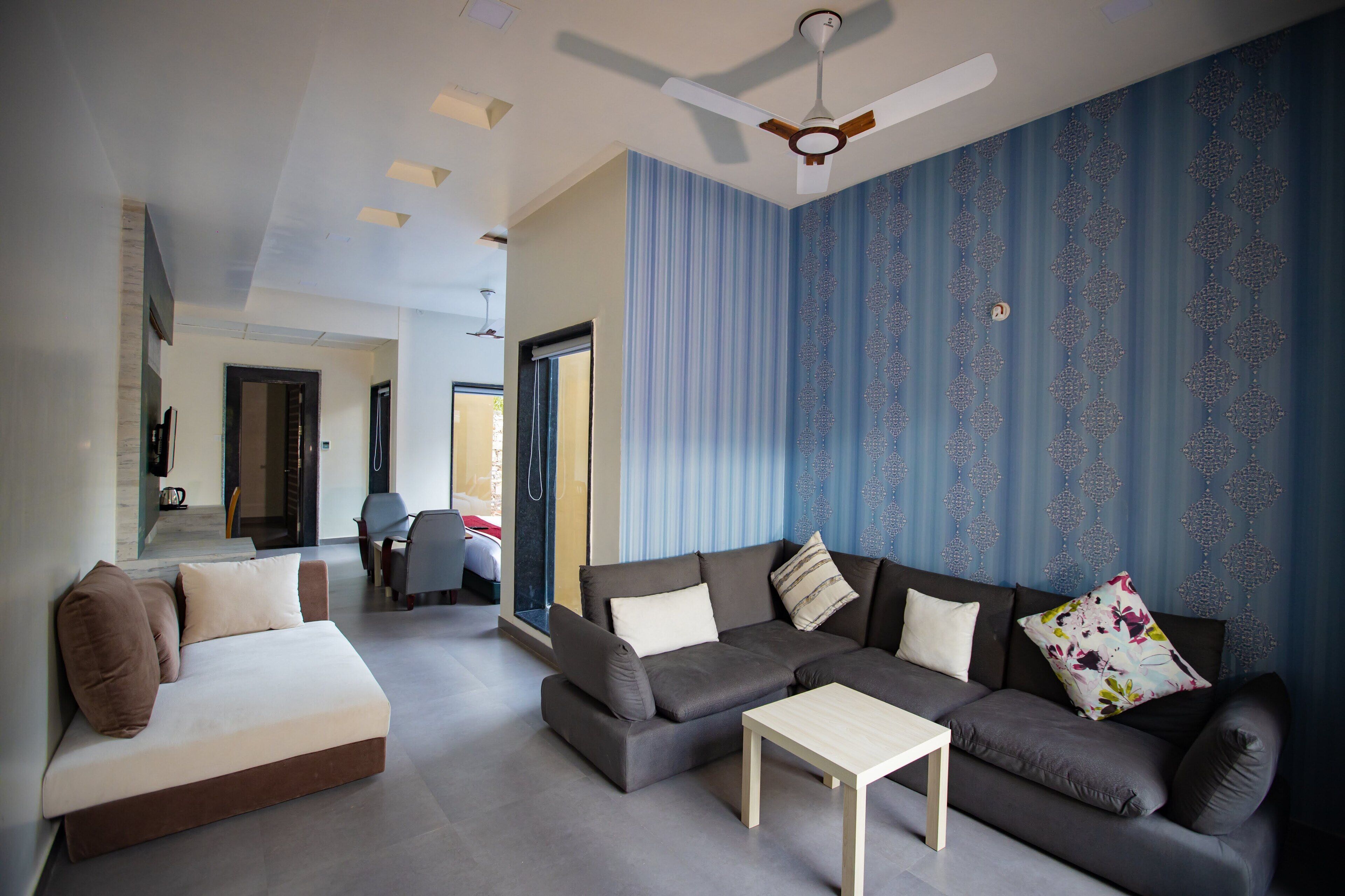 A modern living room with a sectional sofa, a small table, and a ceiling fan.