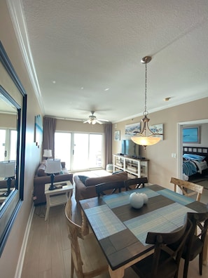 A dining area with a wooden table, chairs, and a ceiling fan. - Beautiful BEACHFRONT condo within walking distance to the popular attractions (Gulf Shores)