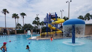 Una piscina con tobogán y plataforma de salto.