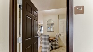 A room with a dining area, a mirror, and a door with a number plate. - Sea View is at the Beach! (Fernandina Beach)