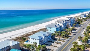 A coastal town with beachfront properties, a clear blue sky, and a road running parallel to the beach. - "Tide Life" - Perfect Sized Family Beach House (Panama City Beach)