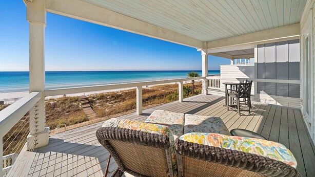 A covered outdoor deck with wicker furniture and a view of the ocean. - "Tide Life" - Perfect Sized Family Beach House (Panama City Beach)