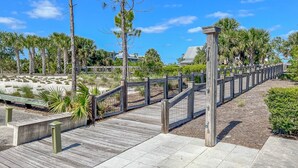 A wooden boardwalk leading to a beach area with a wooden fence and a bench. - Port St. Joe Home | Heated Pool | Dog Friendly | Sleeps 10 (Port St Joe)