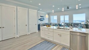 Una cocina moderna con armarios blancos, una isla central e iluminación colgante.