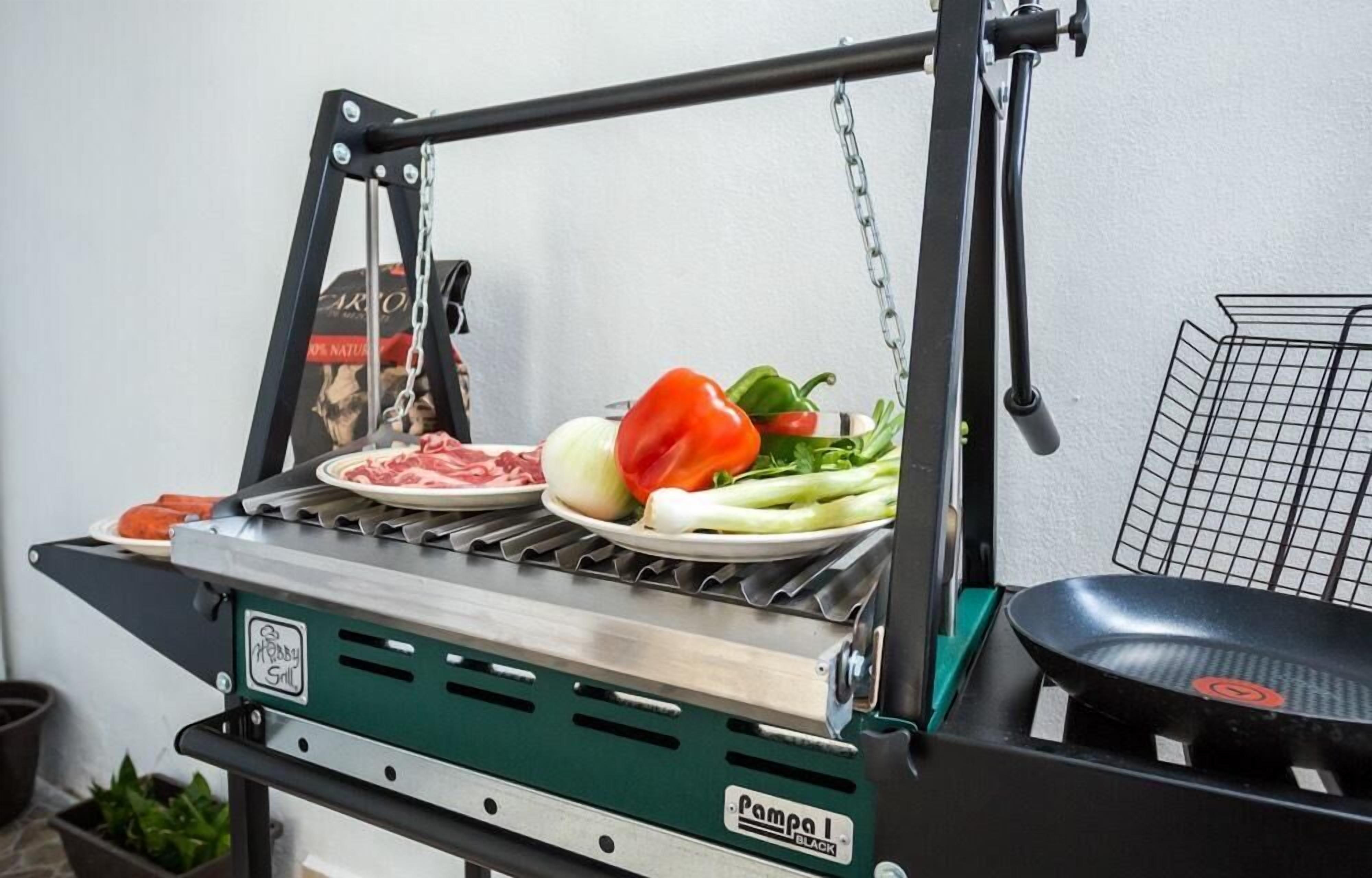 A portable grill with meat and vegetables on it.