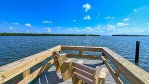 Een houten steiger die zich uitstrekt in kalm water, met een heldere lucht erboven.