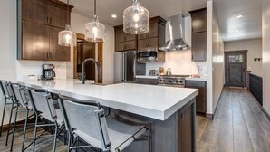 A modern kitchen with a large island, stainless steel appliances, and pendant lighting. - Modern Mountain Luxury - Bonus room, Humidifier, Wi-Fi & Hot Tub! (Kamas)