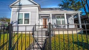 A two-story house with a front porch, a covered entryway, and a small front yard.