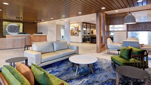 A modern lobby with a reception desk, sofas, and a coffee table. - Fairfield Inn & Suites by Marriott Selinsgrove (Selinsgrove)