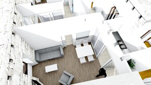 A modern interior with a central seating area, a staircase, and a view of the outside.