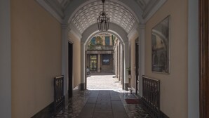 A corridor with a tiled floor, arched ceiling, and a storefront with 'LUJO' signage. - Fiori - Bright & Stylish loft in the heart of Brera (Milano)