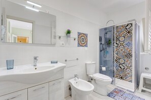 Regadera, secadora de cabello, bidet, toallas